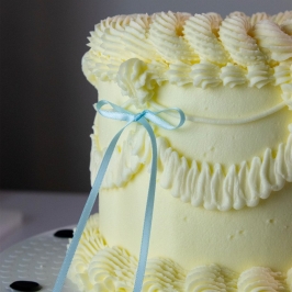 Tarta decorada con topper de lazo de cinta azul PME