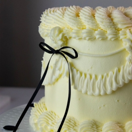 Tarta decorada con topper de lazo de cinta negra PME