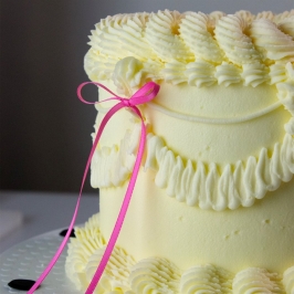 Tarta decorada con topper de lazo de cinta rosa PME